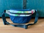 Die Gürteltasche aus blauem Canvas ist formstabil und praktisch ob auf Reisen oder in den Ausgang. Sie ist mit den Gurten verstellbar.